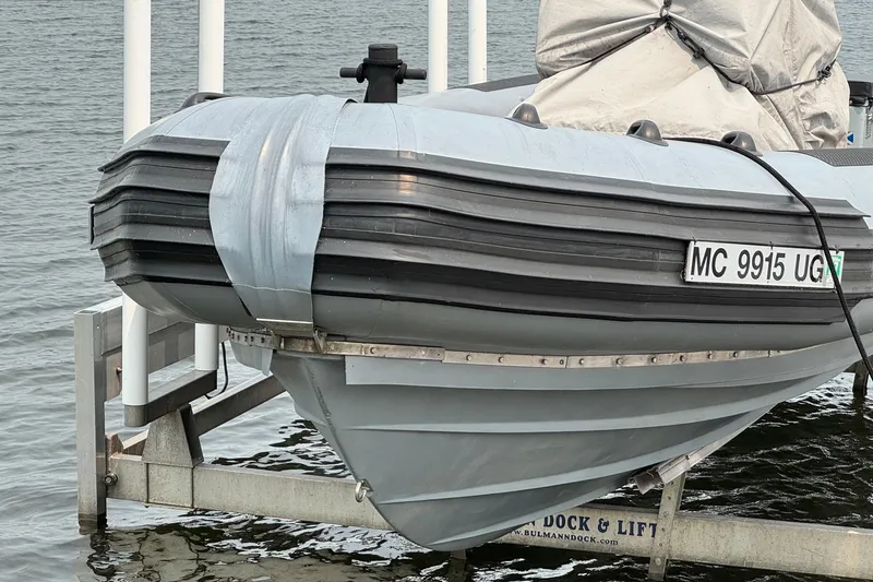 Slide: The Image of 1996 Willard Marine Sea Force 730 boat on lift, docked by the water. - 2