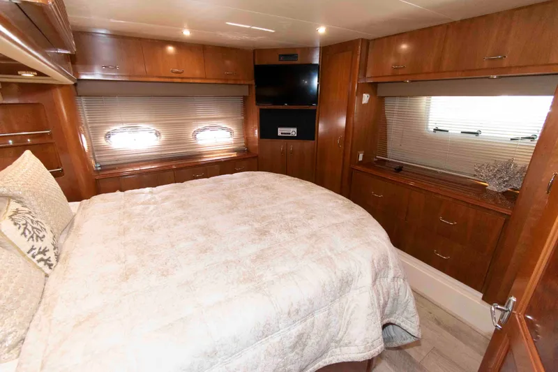 Slide: The Image of Luxurious 2005 Carver 466 Motor Yacht bedroom with elegant wood cabinetry and cozy bedding. - 20