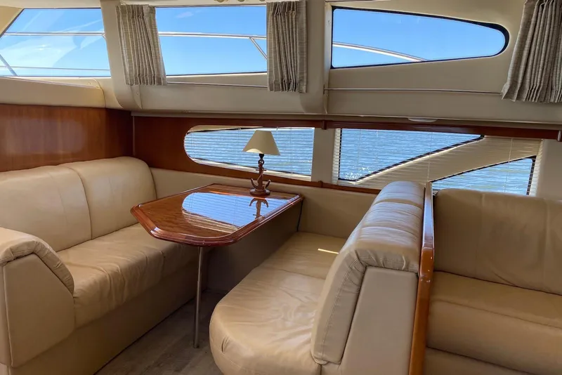 Slide: The Image of Interior of 2005 Carver 466 Motor Yacht with beige seating and wooden table. - 4