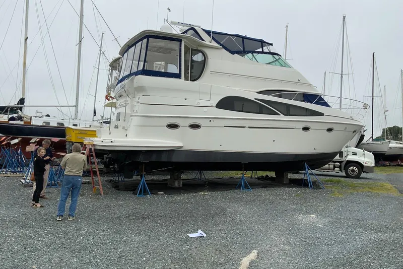 Slide: The Image of 2005 Carver 466 Motor Yacht on stands, surrounded by people, in a boatyard. - 10