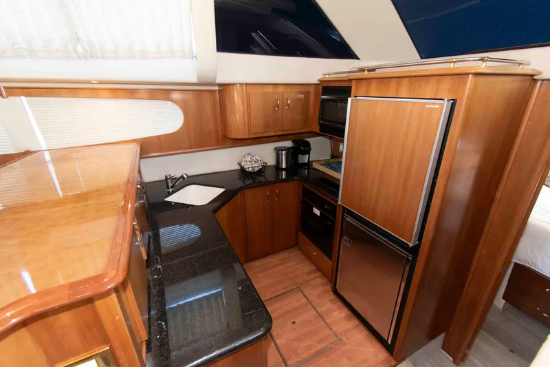 Slide: The Image of Luxurious kitchen interior of 2005 Carver 466 Motor Yacht with wood cabinetry and modern appliances. - 17