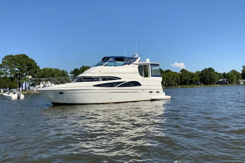 The Image of 2005 Carver 466 Motor Yacht on calm water with trees in the background. - 0