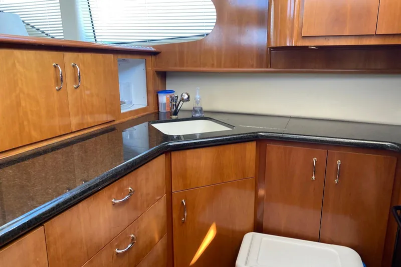 Slide: The Image of Luxurious kitchen area in a 2005 Carver 466 Motor Yacht with wooden cabinetry and sleek countertops. - 6