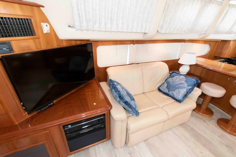 Slide: The Image of Interior of 2005 Carver 466 Motor Yacht with beige sofa, TV, and blue cushions. - 14