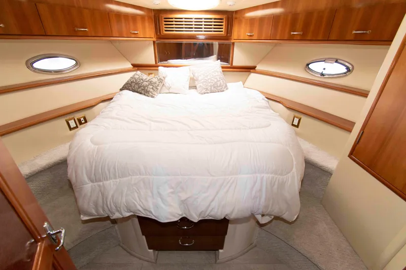 Slide: The Image of Luxurious bedroom interior of 2005 Carver 466 Motor Yacht with cozy bedding and wood accents. - 22