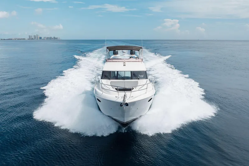 Slide: The Image of Luxury 2012 Princess 60 yacht cruising on open sea with city skyline in background. - 2
