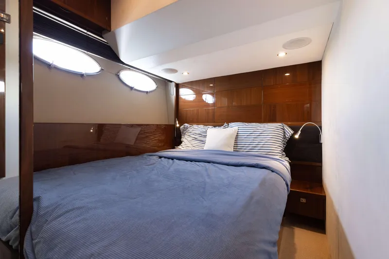 Slide: The Image of Elegant bedroom with double bed, wood paneling, and porthole windows on a 2012 Princess 60 yacht. - 39