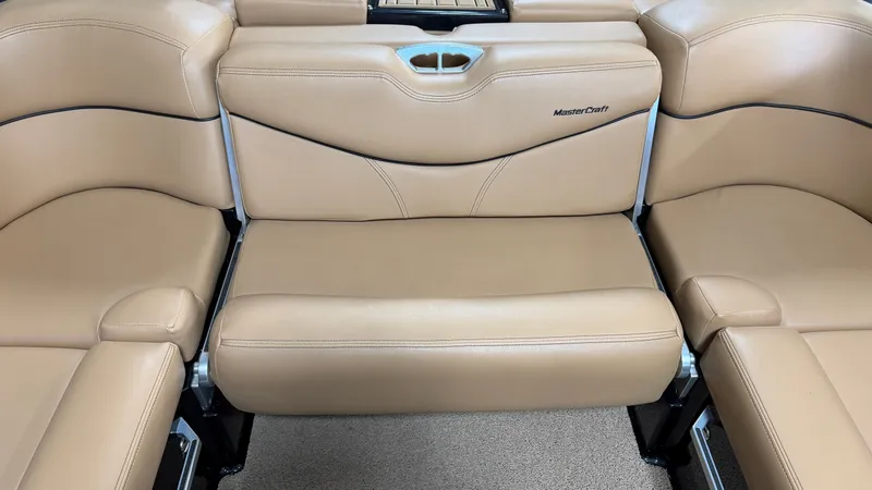 Slide: The Image of The interior of the 2019 MasterCraft XT22 features beige leather seating with a cup holder. - 32
