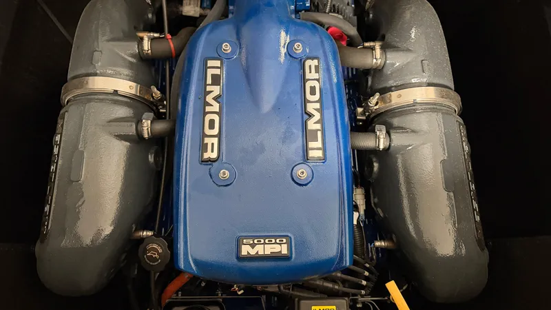 Slide: The Image of The engine compartment features a blue Ilmor 5000 MPI engine with gray components. - 21