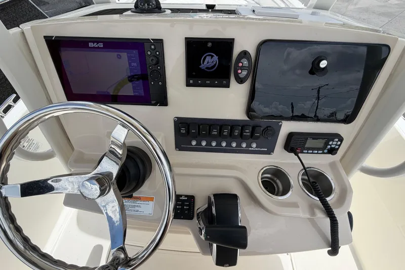Slide: The Image of 2022 Boston Whaler 250 Dauntless helm with steering wheel, controls, and navigation display. - 20