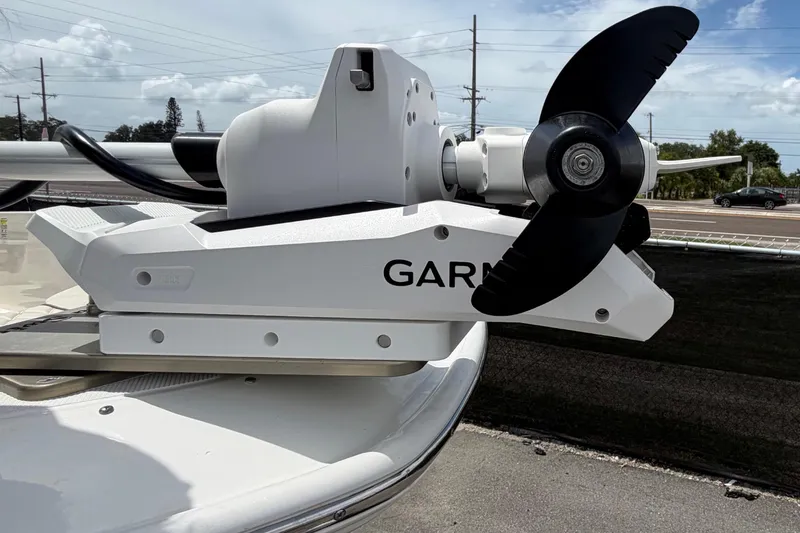 Slide: The Image of A modern boat with a Garmin motor, positioned on a trailer, surrounded by roads and trees. - 36