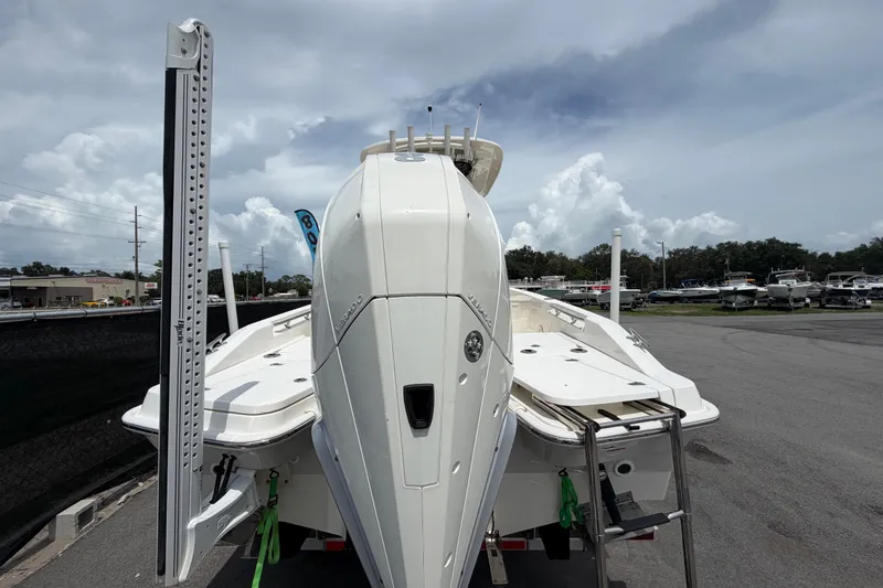 Slide: The Image of 2022 Boston Whaler 250 Dauntless boat, rear view, parked outdoors under cloudy sky. - 3