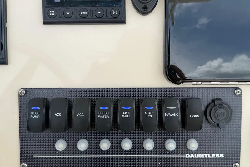 Slide: The Image of Control panel of a 2022 Boston Whaler 250 Dauntless boat with labeled switches. - 23