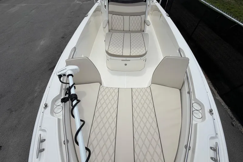Slide: The Image of 2022 Boston Whaler 250 Dauntless boat interior with cushioned seating and Garmin equipment. - 39