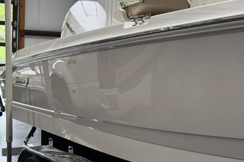 Slide: The Image of 2022 Boston Whaler 250 Dauntless boat side view in a garage setting. - 9