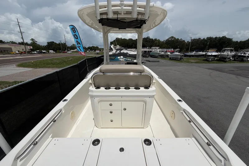Slide: The Image of 2022 Boston Whaler 250 Dauntless boat interior with seating and storage, displayed outdoors. - 12