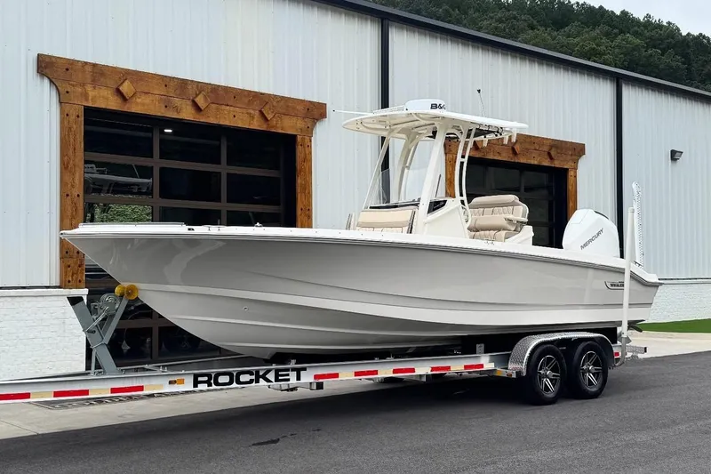 Slide: The Image of 2022 Boston Whaler 250 Dauntless boat on a trailer outside a modern building. - 2
