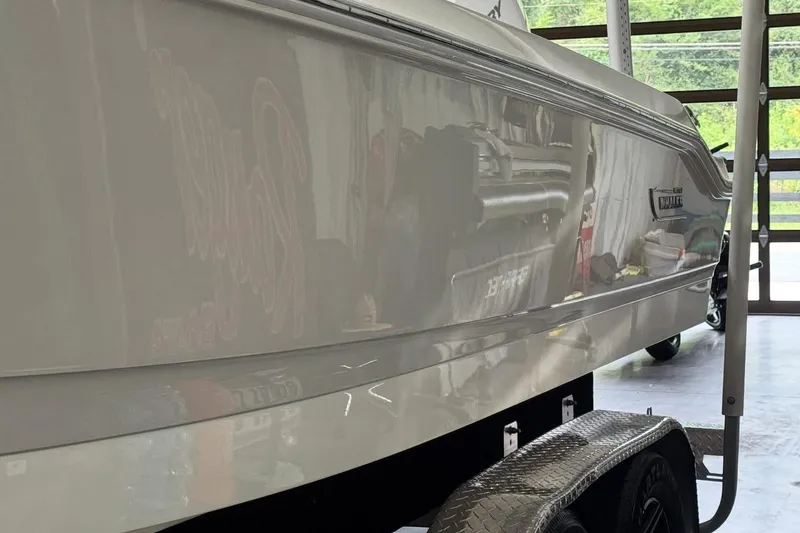 Slide: The Image of 2022 Boston Whaler 250 Dauntless boat on trailer in a garage setting. - 8