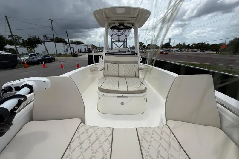 Slide: The Image of 2022 Boston Whaler 250 Dauntless boat interior with cushioned seating and overcast sky. - 40