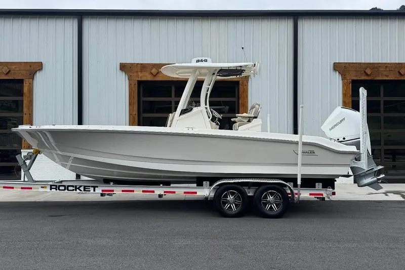 The Image of 2022 Boston Whaler 250 Dauntless boat on trailer, parked outside a building. - 0