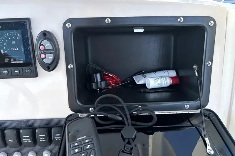 Slide: The Image of Dashboard of 2022 Boston Whaler 250 Dauntless with storage compartment and controls. - 27