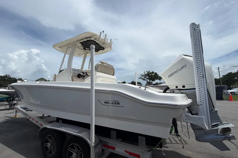 Slide: The Image of 2022 Boston Whaler 250 Dauntless boat on trailer, featuring Mercury engine, under cloudy sky. - 7