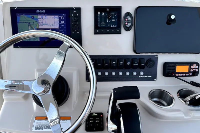 Slide: The Image of Control panel of a 2022 Boston Whaler 250 Dauntless boat with steering wheel and navigation instruments. - 29