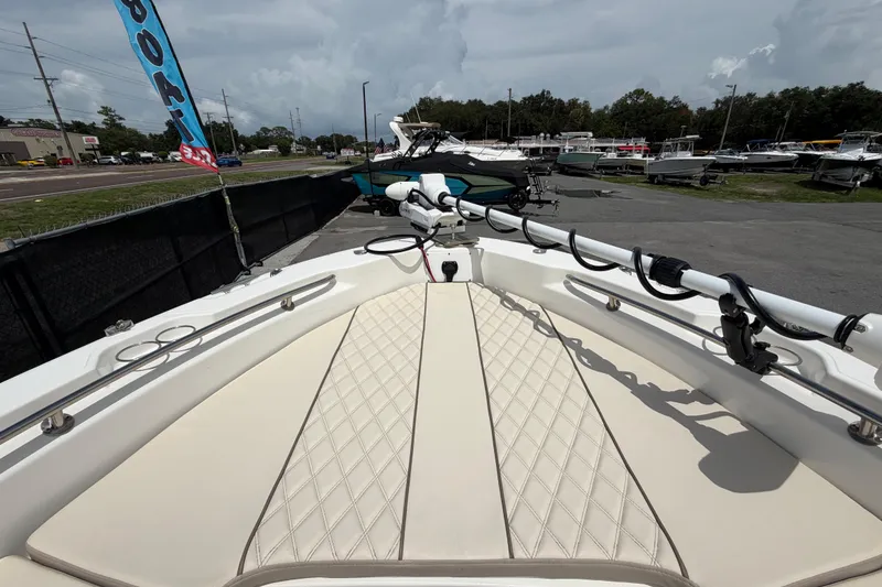 Slide: The Image of 2022 Boston Whaler 250 Dauntless boat deck with cushioned seating and fishing rod holders. - 34