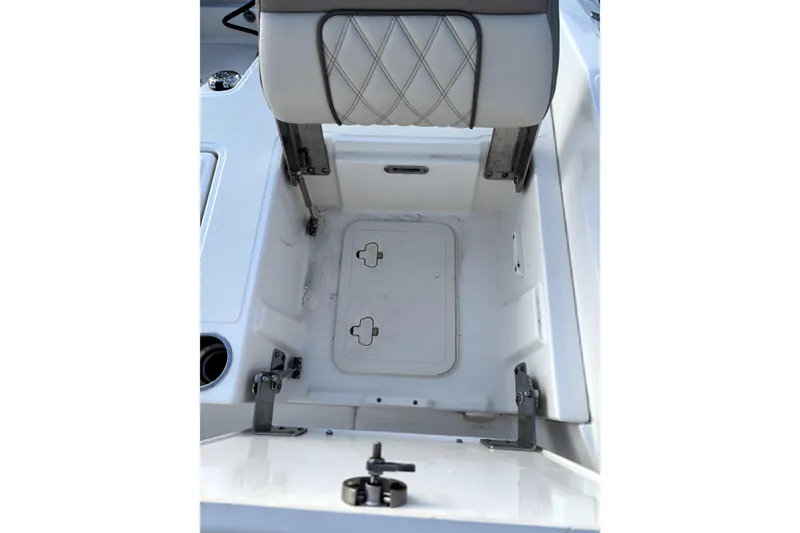 Slide: The Image of 2022 Boston Whaler 250 Dauntless storage compartment with cushioned seat and cup holder. - 26