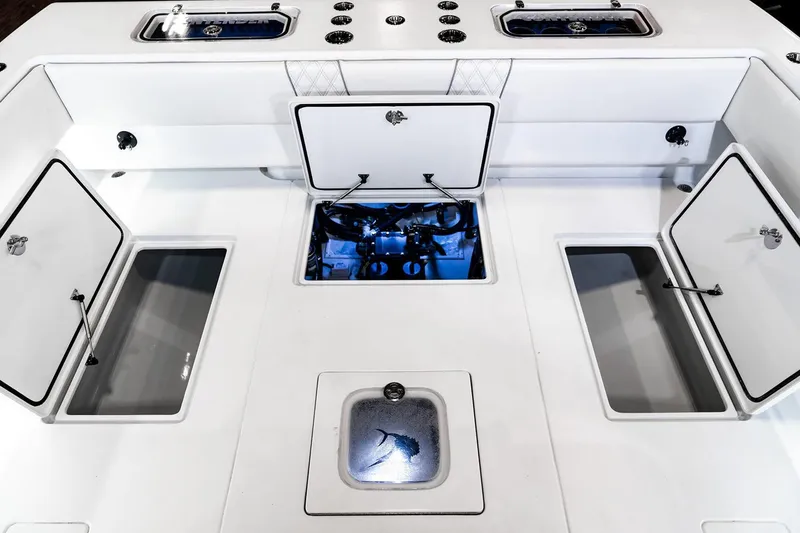 Slide: The Image of Manufacturer Provided Image: 2026 Contender 44 CB boat deck with open storage compartments and engine access. - 9