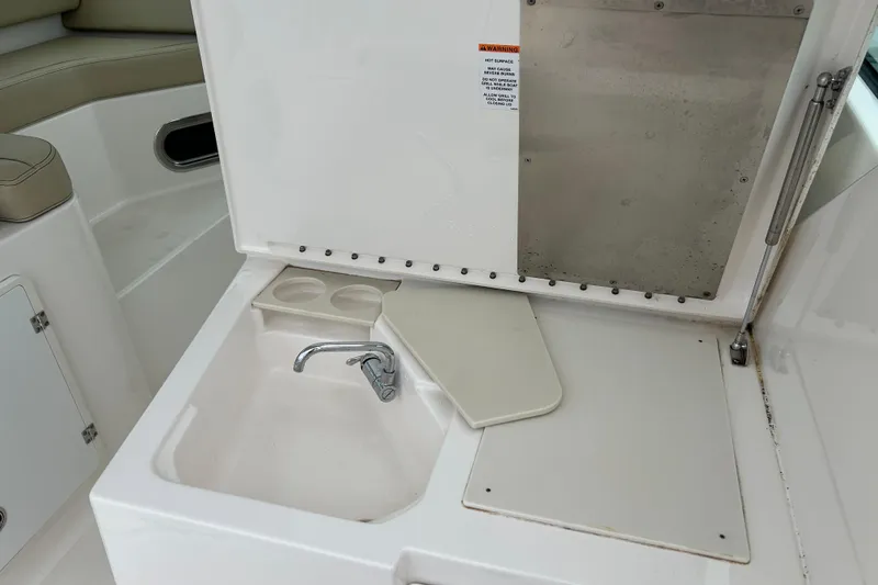 Slide: The Image of 2018 Pursuit DC 325 Dual Console boat sink and faucet area with cup holders. - 8