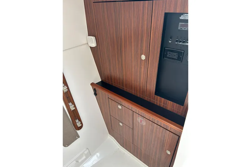 Slide: The Image of 2018 Pursuit DC 325 Dual Console interior with wood paneling and control panel. - 15