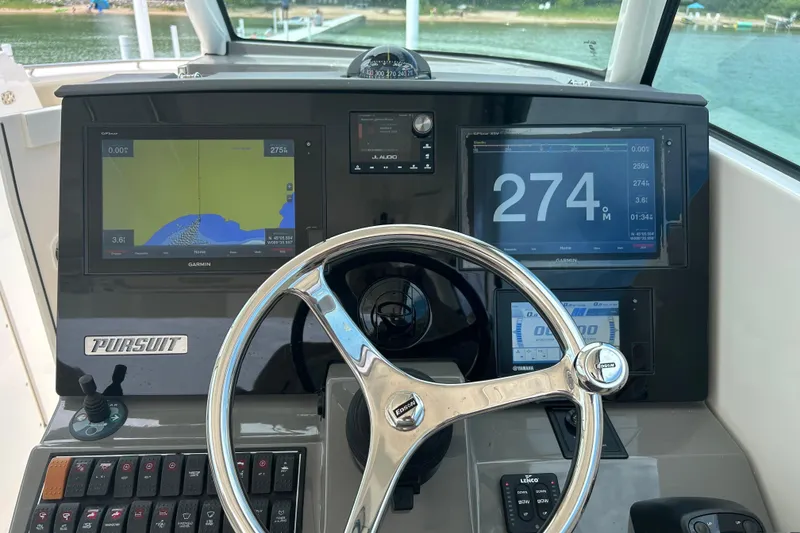 Slide: The Image of 2018 Pursuit DC 325 Dual Console dashboard with Garmin navigation displays and steering wheel. - 12