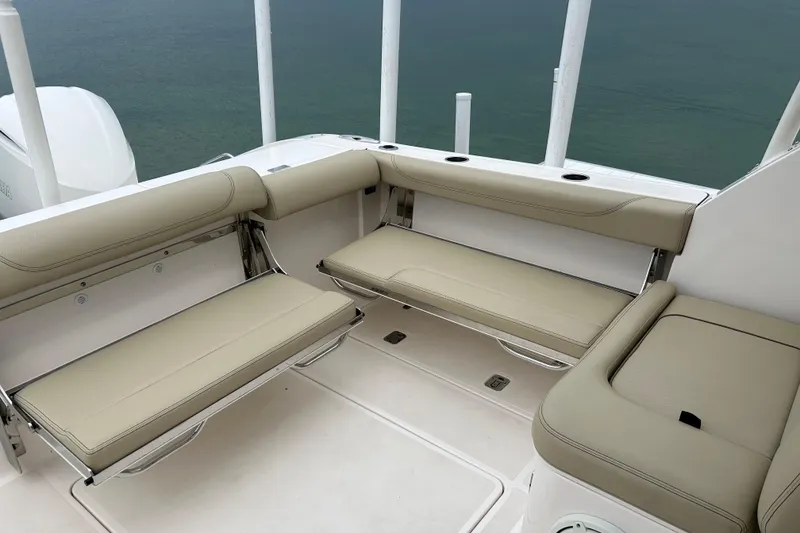 Slide: The Image of 2018 Pursuit DC 325 Dual Console boat interior with beige seating and ocean view. - 5