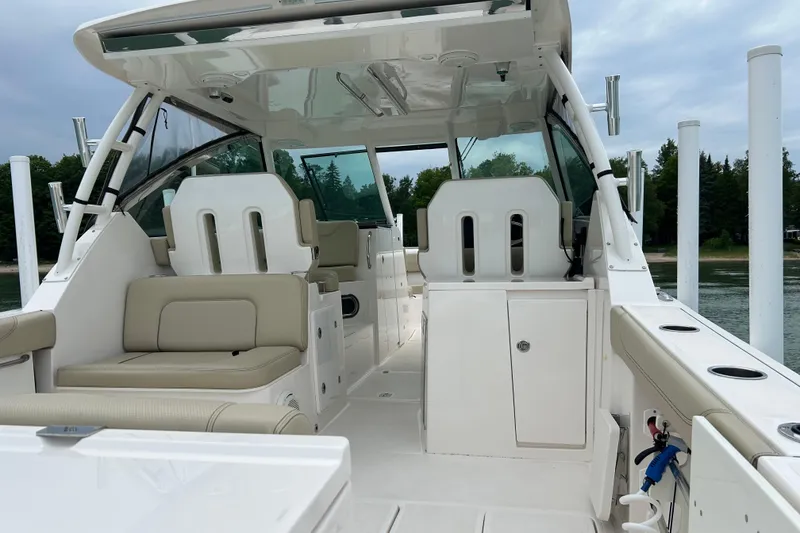 Slide: The Image of 2018 Pursuit DC 325 Dual Console boat interior with beige seating and sleek design. - 6