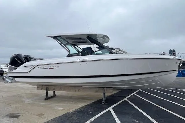 The Image of 2027 Monterey Elite 30 OB boat on display, sleek white design, parked on a marina. - 0