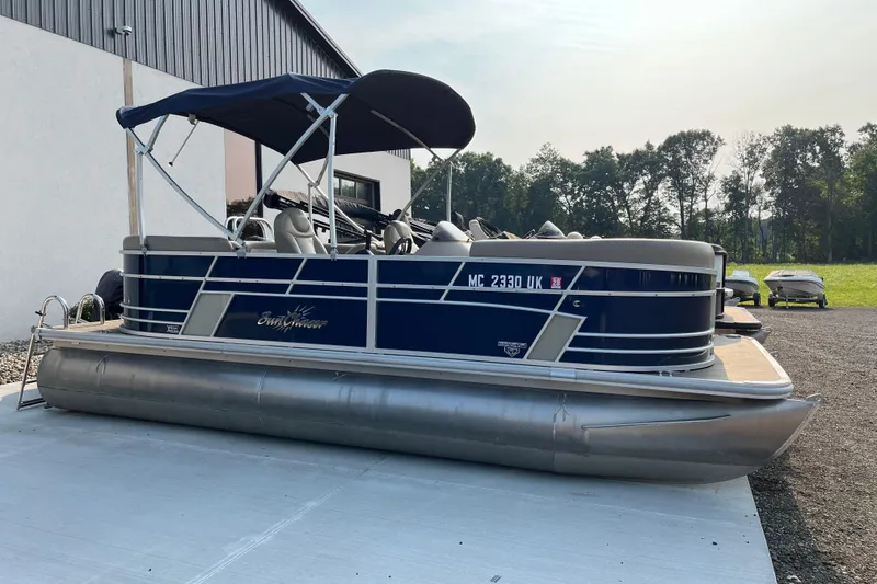 Slide: The Image of 2019 SunChaser Geneva Cruise 20 LR pontoon boat with canopy, parked outdoors. - 1