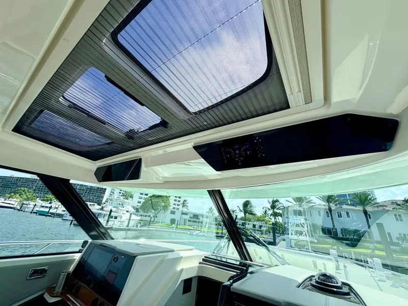 Slide: The Image of The image shows the cockpit of a 2022 Tiara Yachts 43 LE with a large glass roof. - 26
