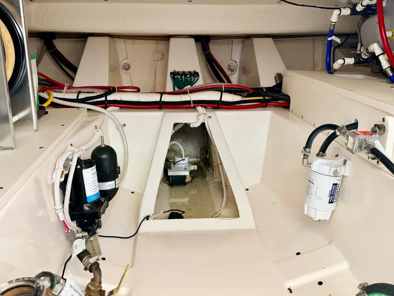 Slide: The Image of The engine room of a 2022 Tiara Yachts 43 LE, featuring wiring and filters. - 47