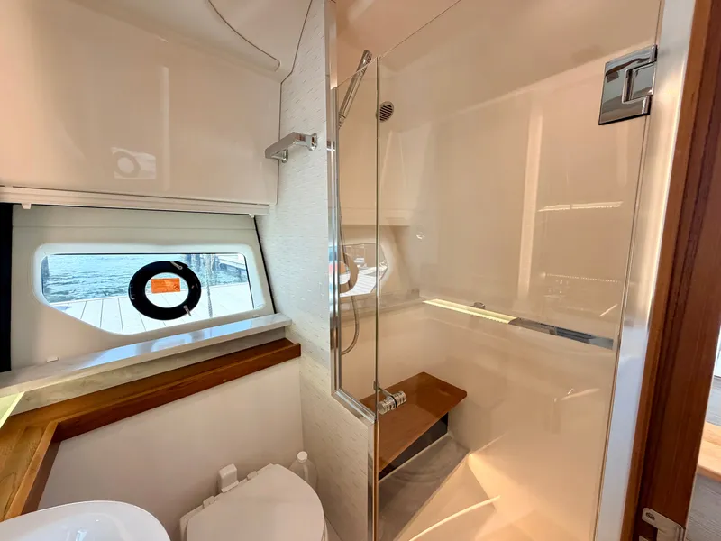 Slide: The Image of The image shows a modern yacht bathroom with a shower, toilet, and window. - 34