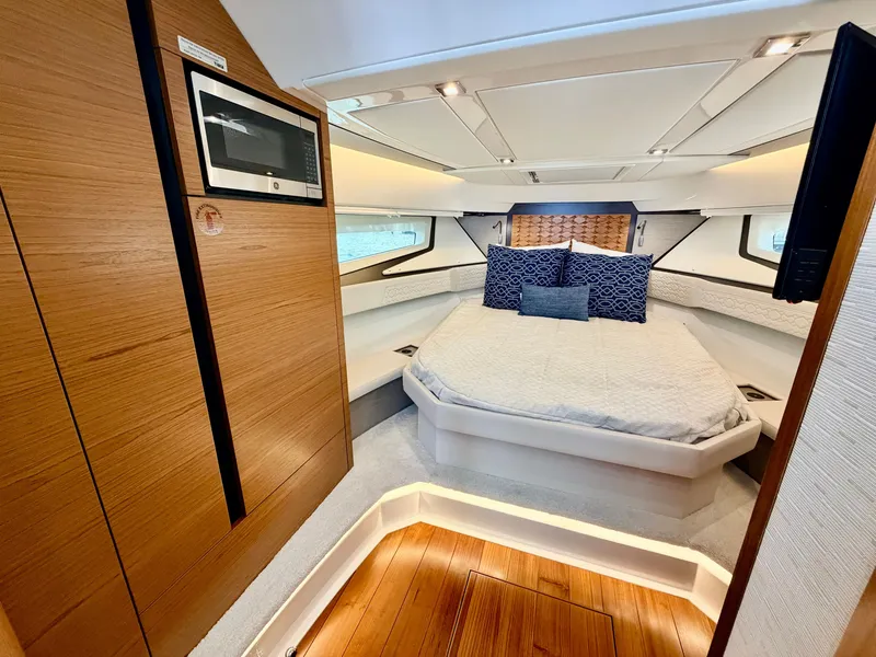 Slide: The Image of The 2022 Tiara Yachts 43 LE cabin features a cozy bed and wood accents. - 27