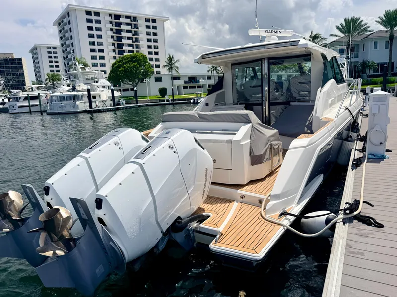 Slide: The Image of A 2022 Tiara Yachts 43 LE docked, featuring two large outboard engines and a sleek design. - 41