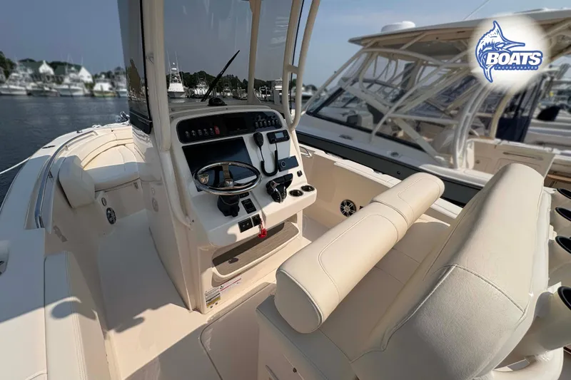 Slide: The Image of 2024 Grady-White Fisherman 257 boat interior with helm and seating, docked at marina. - 7