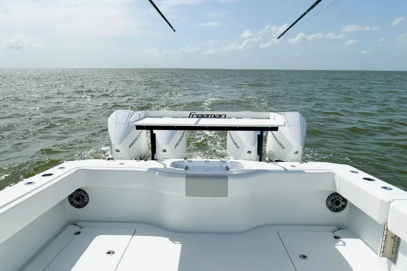 Slide: The Image of 2024 Freeman 38 boat with twin Mercury engines cruising on open water. - 19