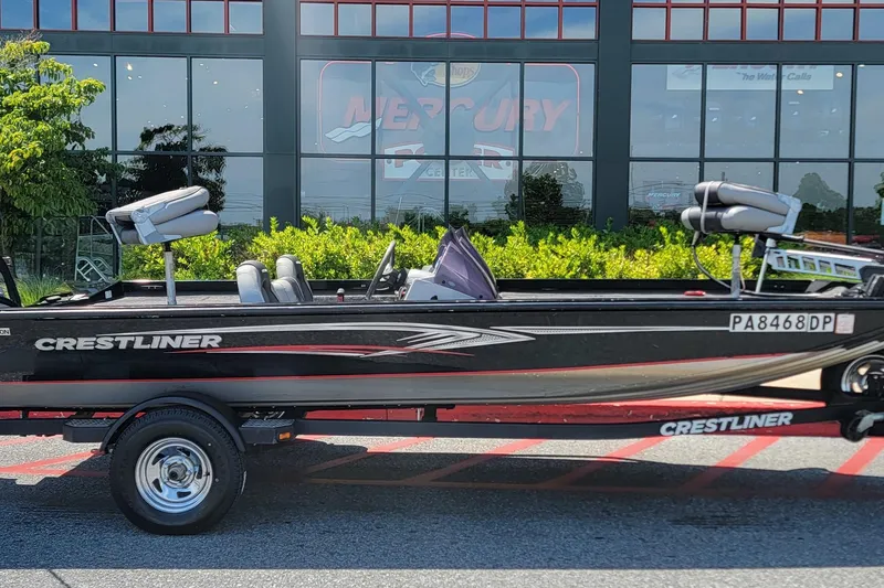 Slide: The Image of 2015 Crestliner VT 18 boat on trailer, parked outside a Mercury dealership. - 2