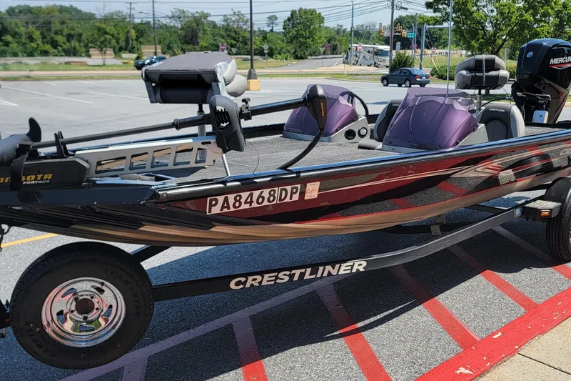 Slide: The Image of 2015 Crestliner VT 18 boat on trailer in parking lot, featuring sleek design and modern equipment. - 7