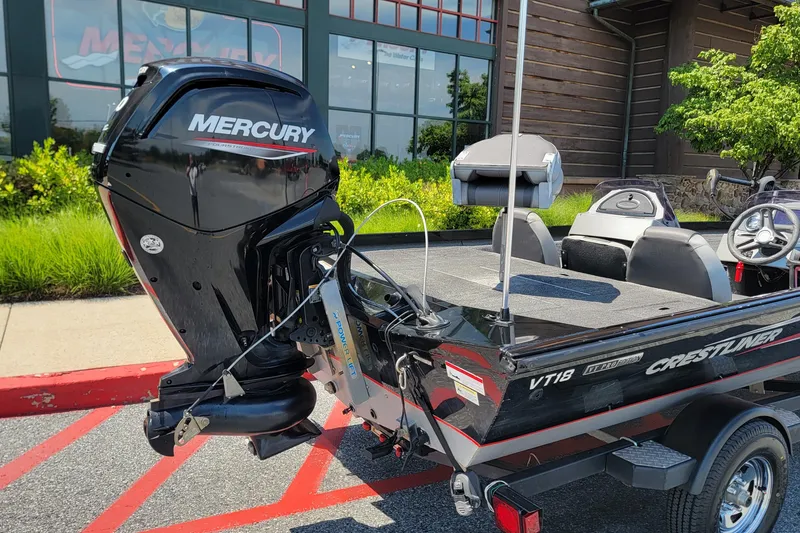 Slide: The Image of 2015 Crestliner VT 18 boat with Mercury outboard motor, parked outdoors. - 1