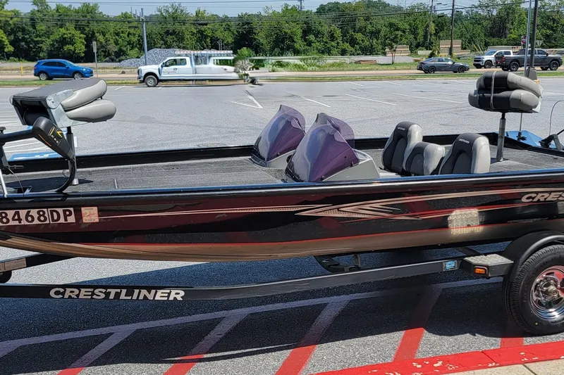 Slide: The Image of 2015 Crestliner VT 18 fishing boat parked in a lot, featuring dual windshields and seating. - 10