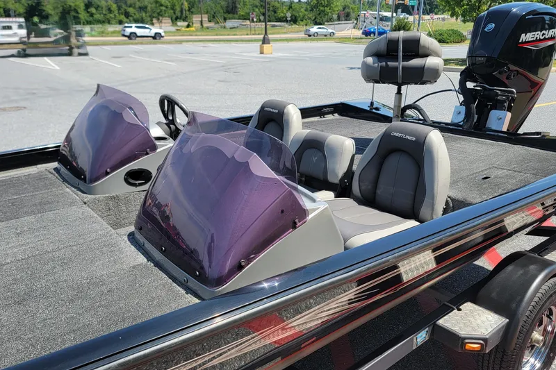 Slide: The Image of 2015 Crestliner VT 18 boat with dual windshields and Mercury outboard motor in parking lot. - 9