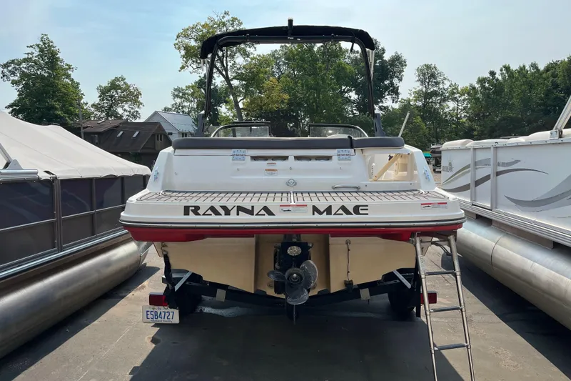 Slide: The Image of 2022 Bayliner VR5 Bowrider I/O boat docked, rear view with ladder and name "Rayna Mae." - 2